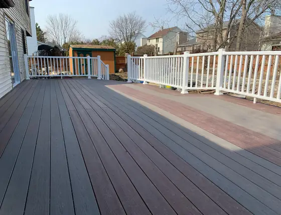 Composite deck with white railing overlooking a fenced backyard