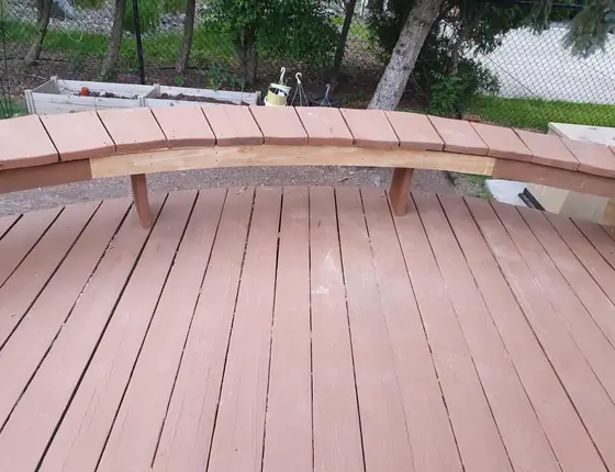 Curved built in bench on a stained wood deck