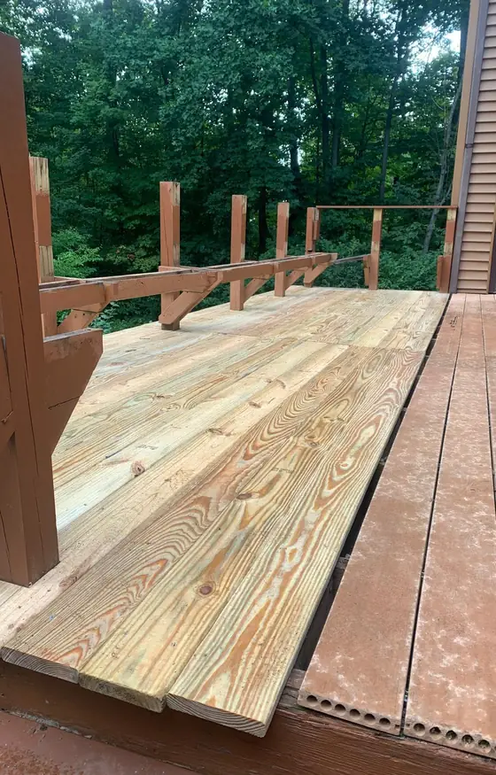 Deck framing with railing posts and new boards on a home