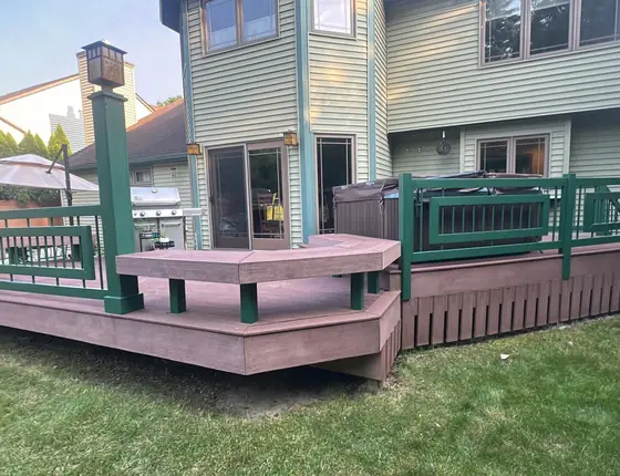 Backyard deck with green railing posts and a seating area