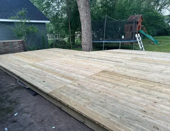 Large ground level pressure treated deck platform in a backyard