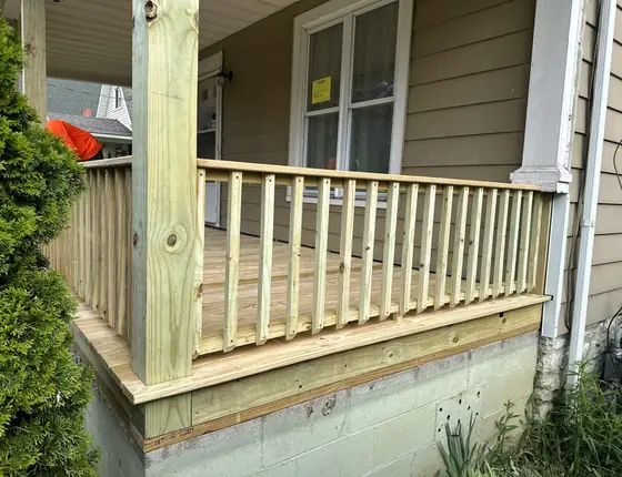 Wood porch deck with square baluster railing and a thick corner post