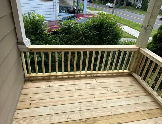 Corner of a new wood porch deck with baluster railing