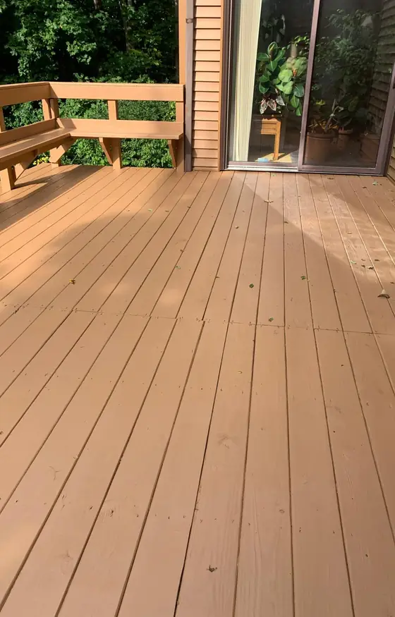 Freshly stained cedar tone deck beside a sliding glass door