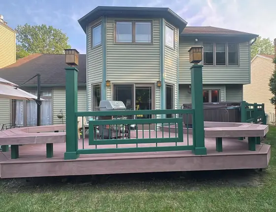 Two level backyard deck with lantern posts and green railing