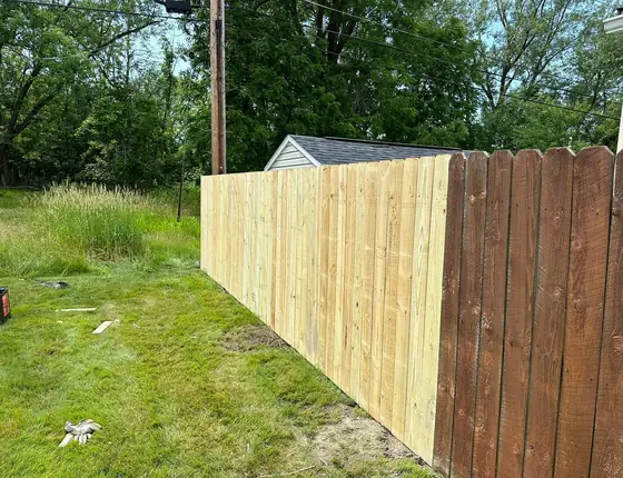 New fence panels meeting an older brown fence