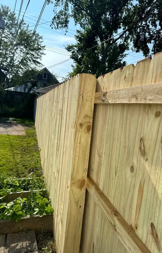 Corner of a new pressure treated wood privacy fence