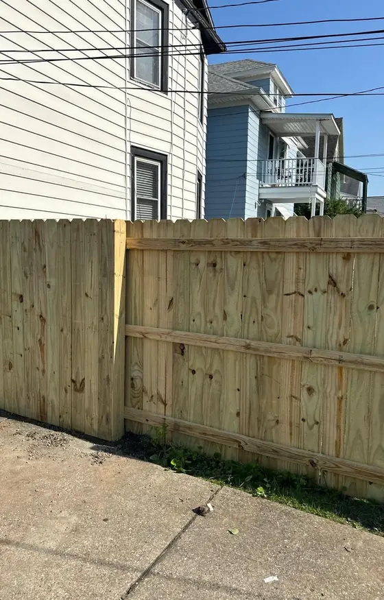 New wood fence panels beside a concrete walkway
