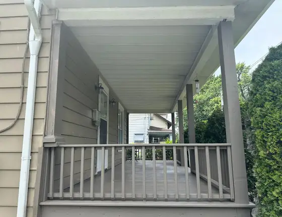 Covered porch with a gray baluster railing