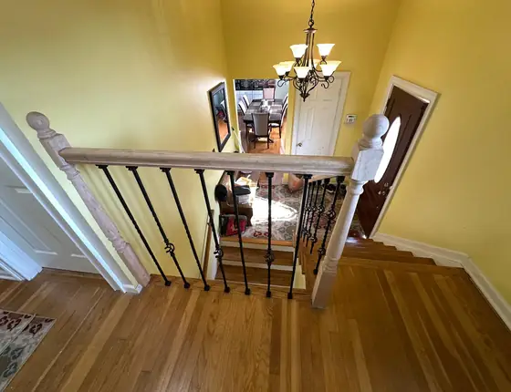 Interior stair railing with iron balusters and a wood newel post