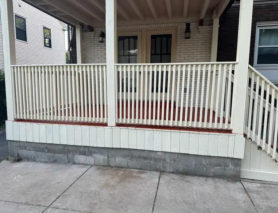 Cream porch railing with side steps along a front porch