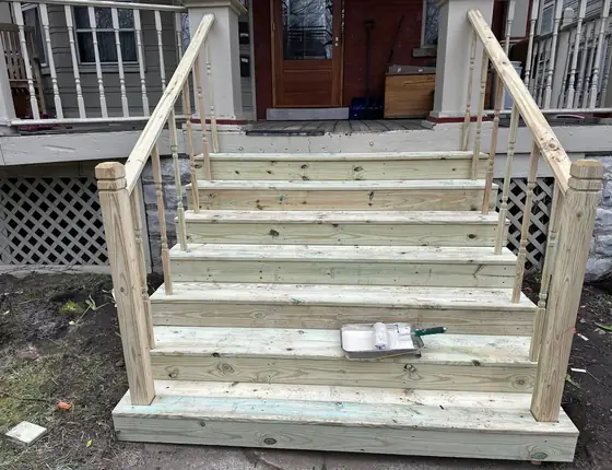 Front view of new wood porch stairs with handrails on both sides