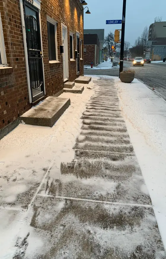Sidewalk and entry steps cleared at a brick building