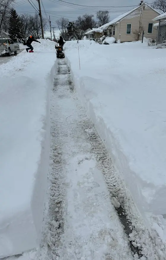 Cleared sidewalk between tall snow banks