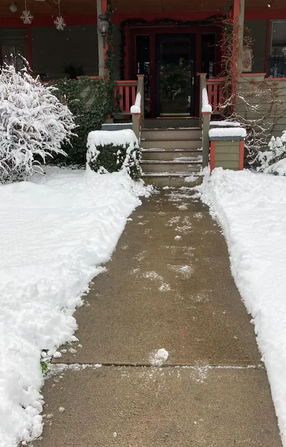 Front walk cleared up to a porch after snow