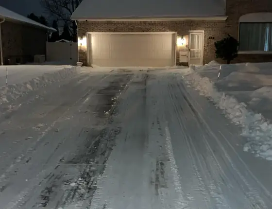 Wide driveway cleared at night with clean plow lines