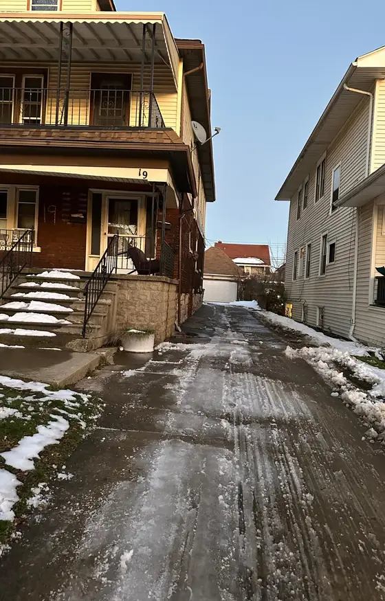 Shared driveway treated for ice beside two story homes